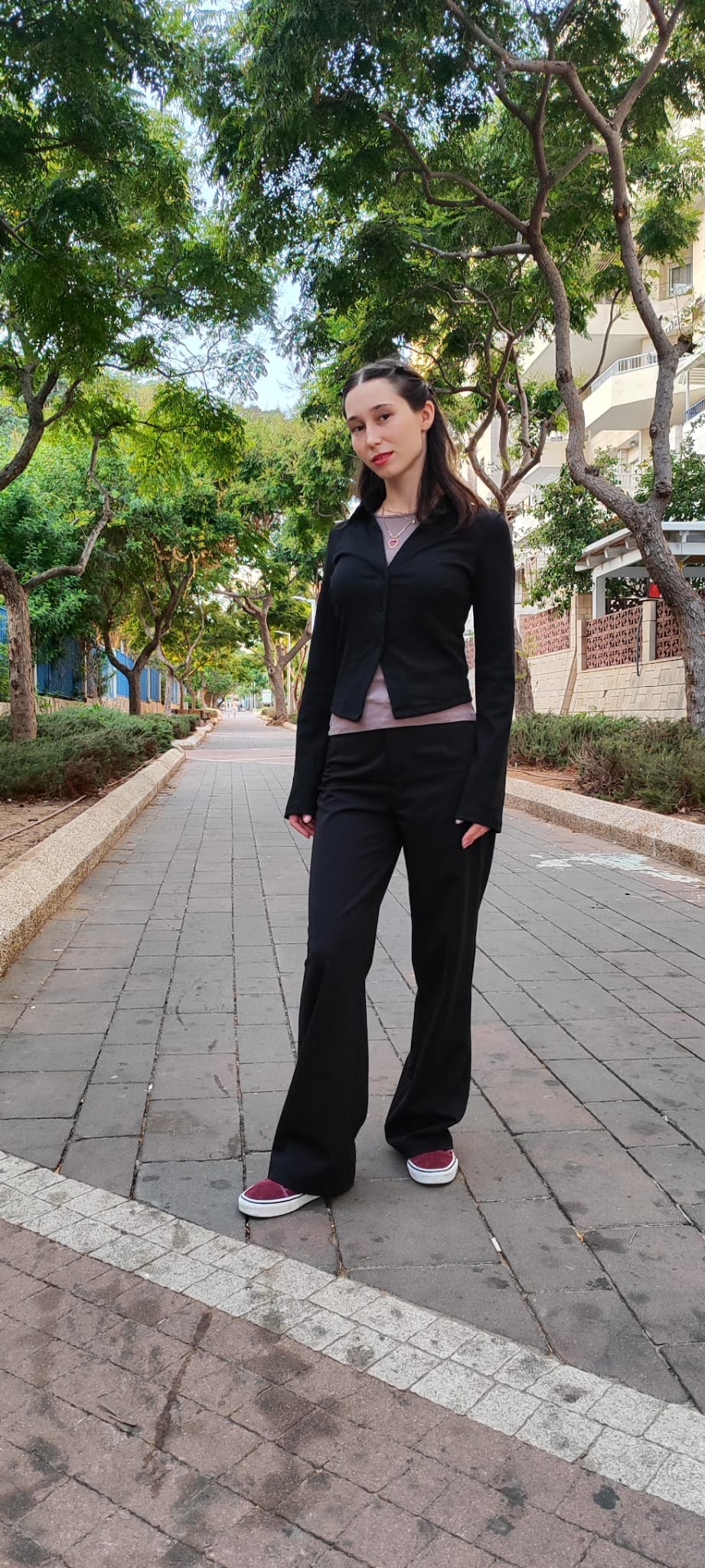 רבקה גוכמן בלוק שחור עם נעלי סניקרס, ברחוב ירוק